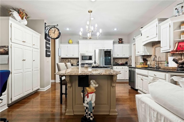 kitchen with dark wood-style flooring, open shelves, appliances with stainless steel finishes, a sink, and a kitchen bar