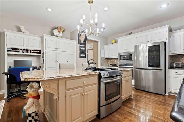 kitchen featuring appliances with stainless steel finishes, visible vents, a kitchen island, and dark wood-type flooring