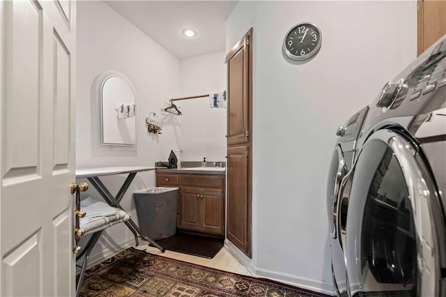 clothes washing area with separate washer and dryer, a sink, cabinet space, and recessed lighting