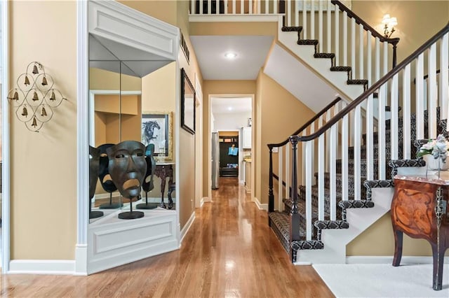 entryway featuring stairs, wood finished floors, visible vents, and baseboards