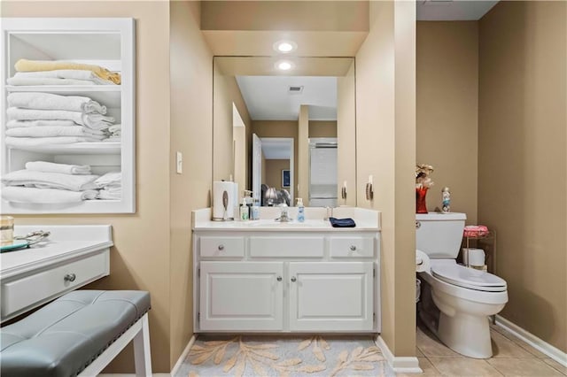 bathroom featuring tile patterned flooring, vanity, toilet, and baseboards