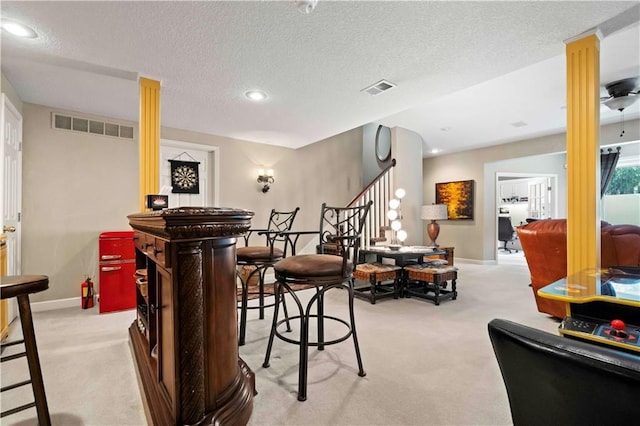 bar featuring visible vents, stairway, carpet flooring, and a textured ceiling