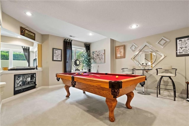 game room with carpet floors, a healthy amount of sunlight, and a textured ceiling