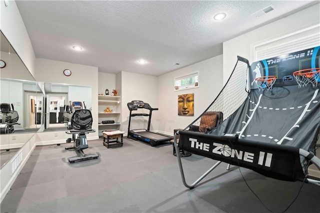 workout area featuring a textured ceiling, visible vents, and recessed lighting