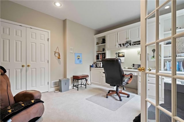 office area featuring light carpet and visible vents