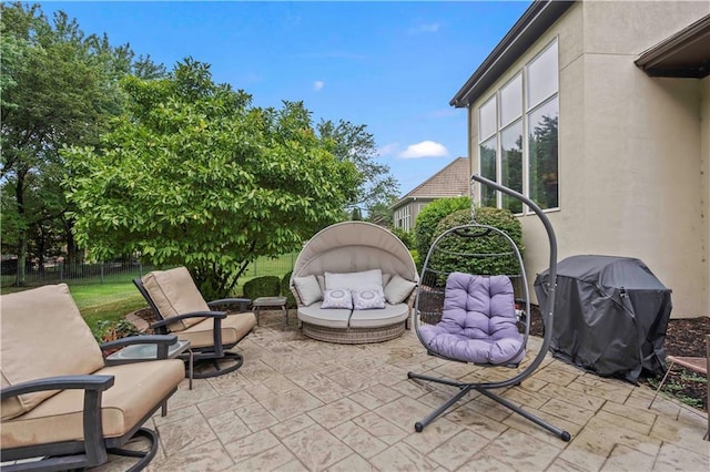 view of patio with area for grilling, fence, and an outdoor living space