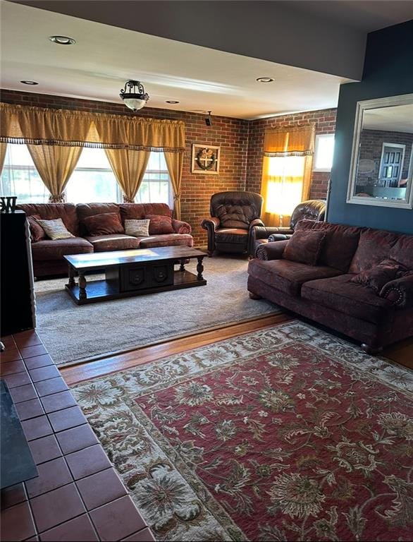 living room featuring brick wall and tile patterned flooring