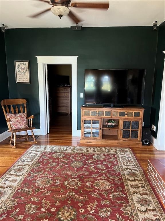 living room featuring wood-type flooring and ceiling fan