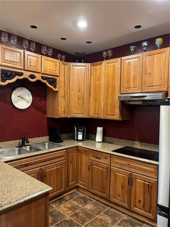 kitchen featuring sink, black electric stovetop, range hood, and dark tile patterned flooring