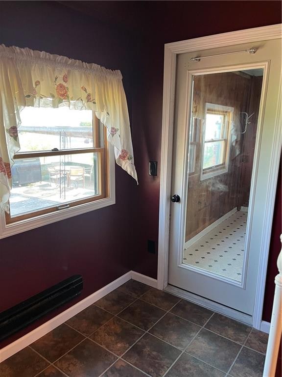 doorway to outside featuring dark tile patterned floors