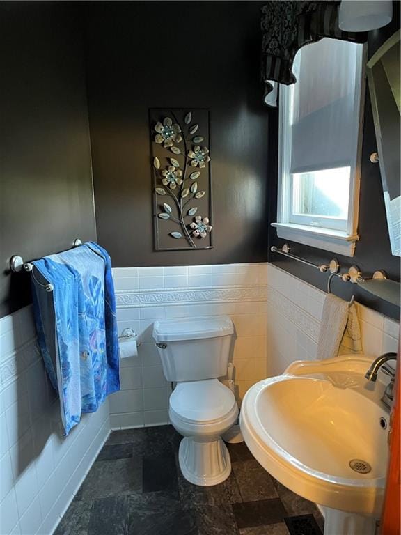 bathroom with sink, tile walls, toilet, and tile patterned flooring