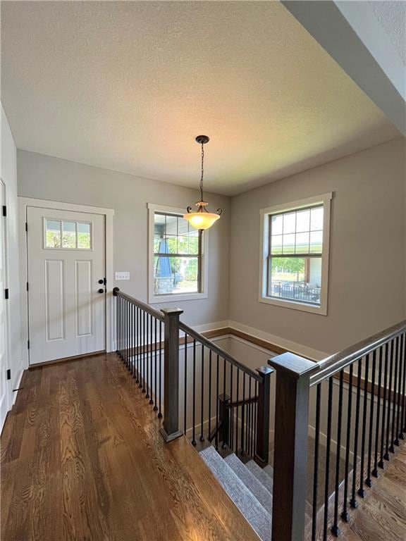 entryway featuring dark wood-type flooring and a textured ceiling