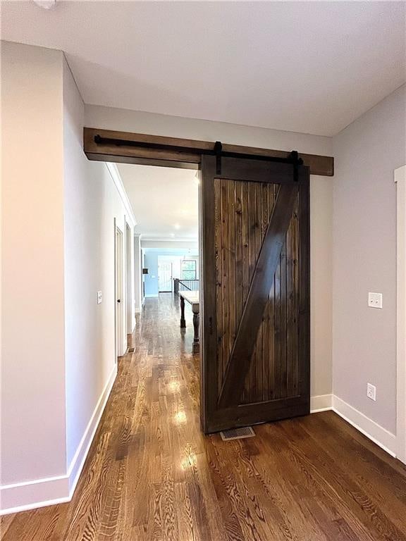 hallway with hardwood / wood-style floors and a barn door