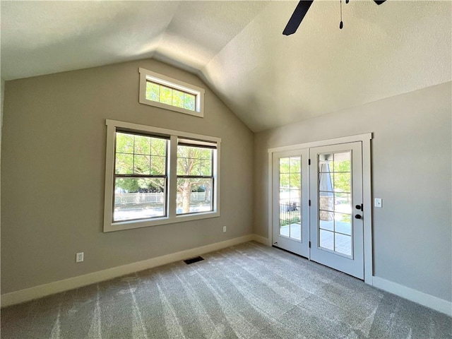 empty room featuring ceiling fan, lofted ceiling, carpet, and french doors