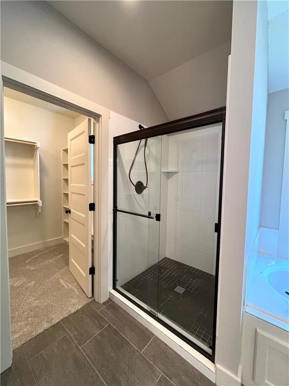 bathroom featuring tile patterned flooring, lofted ceiling, and separate shower and tub