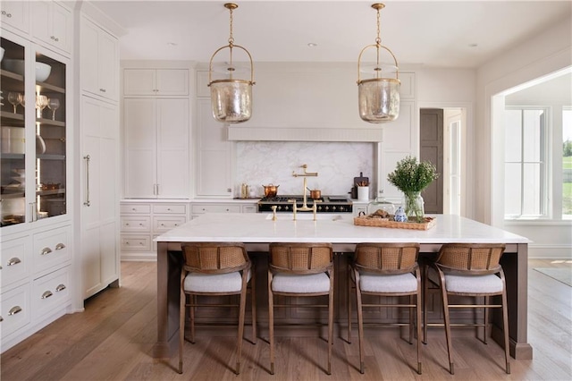 kitchen featuring hanging light fixtures, a breakfast bar, and a center island with sink