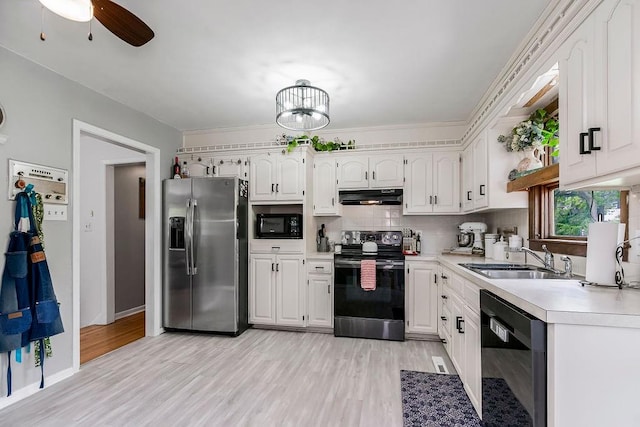 kitchen with black appliances, sink, light wood-type flooring, backsplash, and white cabinets