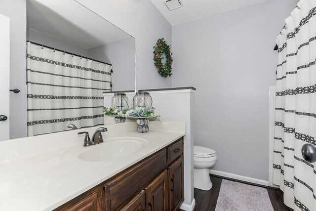 bathroom with vanity, hardwood / wood-style floors, and toilet