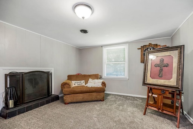 living area featuring ornamental molding, carpet floors, and a fireplace