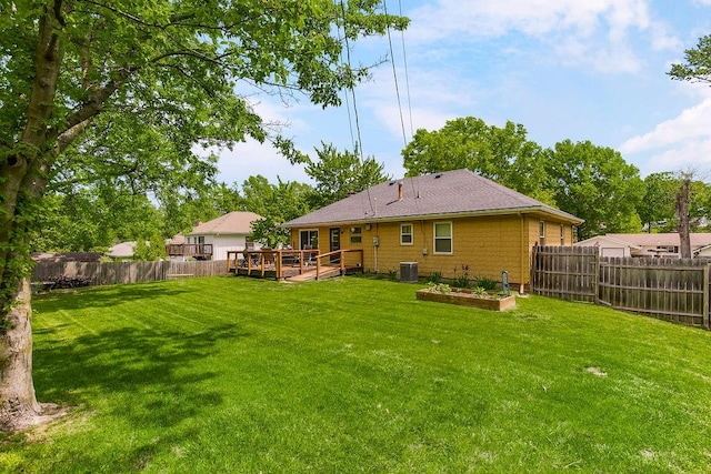 rear view of house with a yard, a deck, and cooling unit