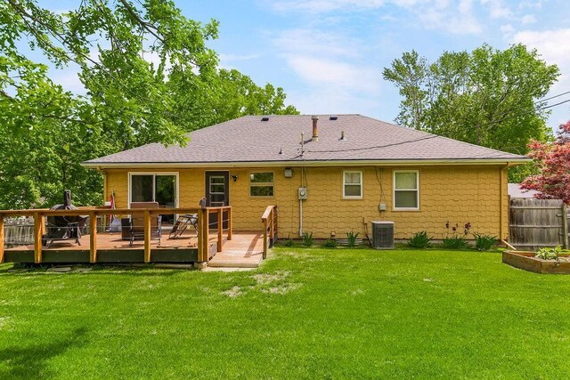 rear view of property featuring a wooden deck, a lawn, and central AC unit