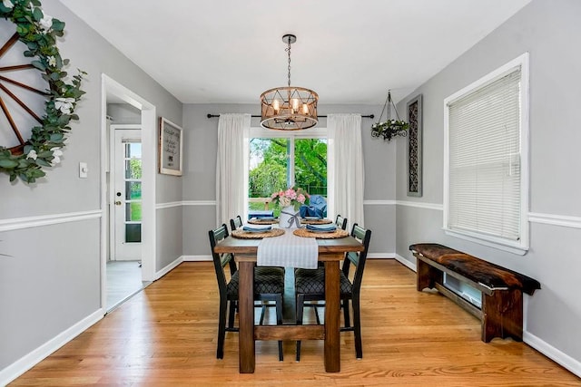 dining space with an inviting chandelier and light hardwood / wood-style flooring