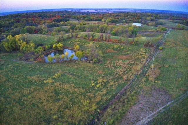 aerial view at dusk featuring a water view