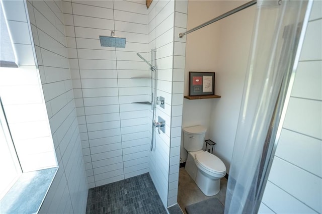 bathroom with toilet and a tile shower