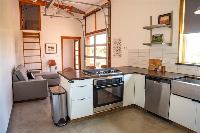 kitchen featuring plenty of natural light, tasteful backsplash, white cabinets, and stainless steel appliances