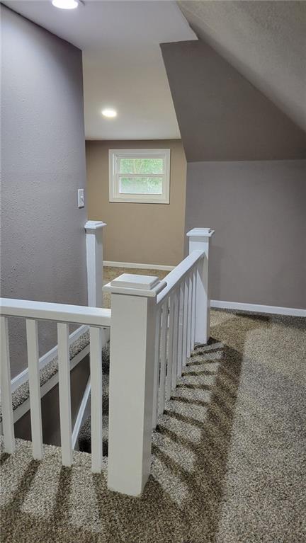 stairs featuring vaulted ceiling and carpet floors