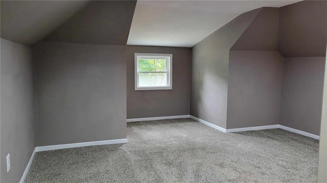 additional living space featuring carpet flooring and vaulted ceiling