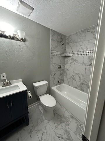 full bathroom with a textured ceiling, toilet, bathing tub / shower combination, vanity, and marble finish floor