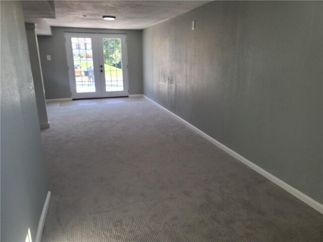 unfurnished room featuring french doors and carpet