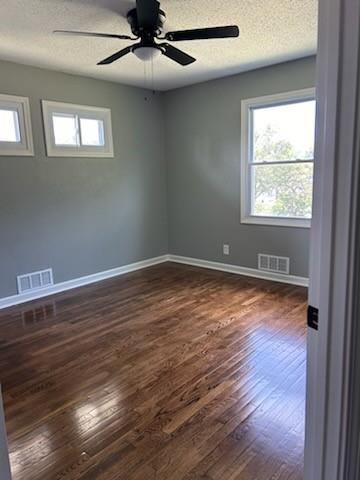 unfurnished room featuring ceiling fan, wood-type flooring, and a textured ceiling