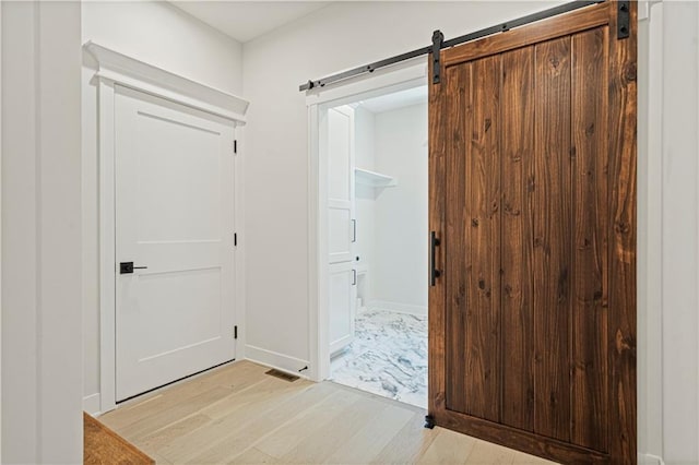 entryway featuring a barn door and light wood-type flooring