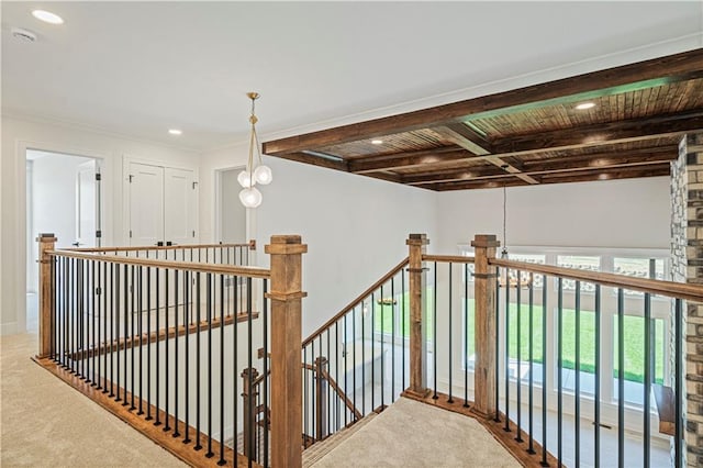 staircase featuring beam ceiling and carpet