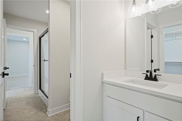 bathroom featuring vanity and a shower with door