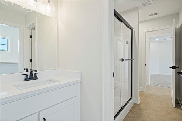 bathroom with vanity and a shower with door