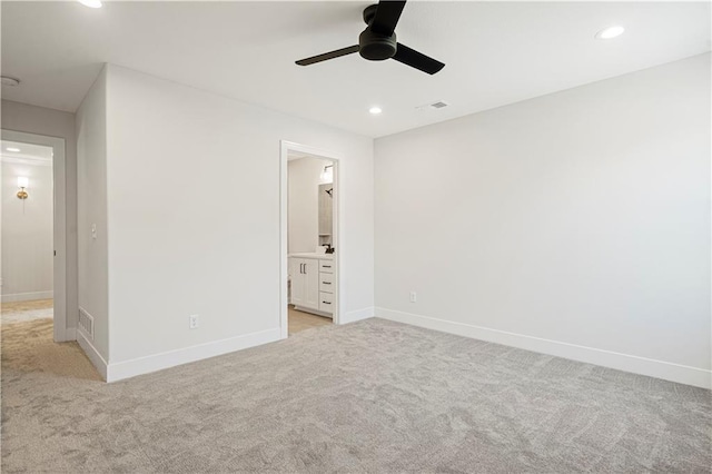 unfurnished bedroom with light carpet, ceiling fan, and ensuite bathroom