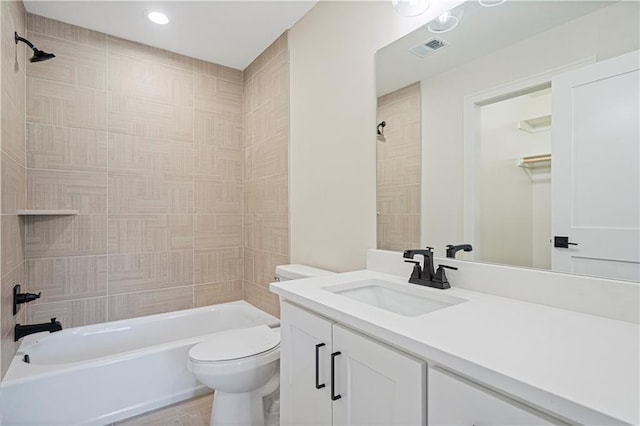 full bathroom featuring tiled shower / bath, vanity, and toilet