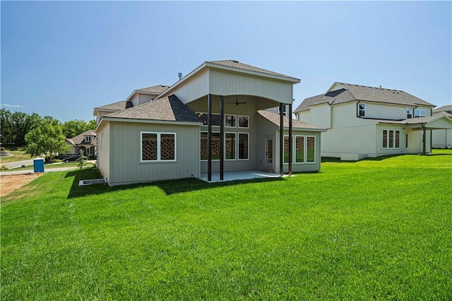 back of property with ceiling fan, a yard, and a patio area