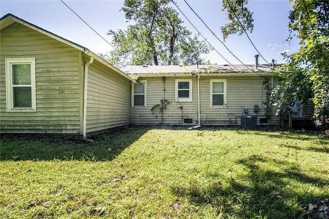 rear view of house with a yard and cooling unit