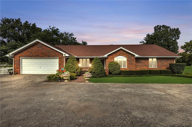 ranch-style home with a yard and a garage