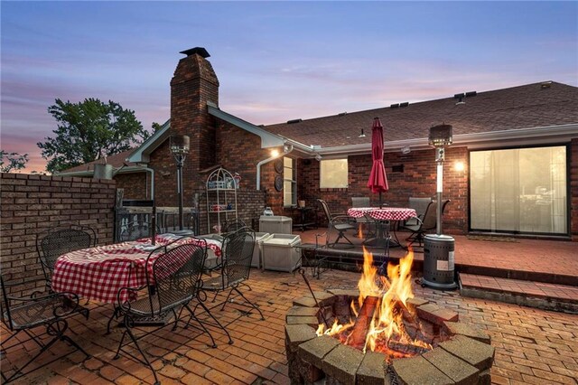 patio terrace at dusk featuring an outdoor fire pit