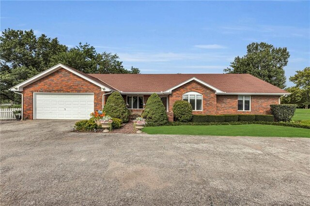 single story home featuring a garage and a front lawn