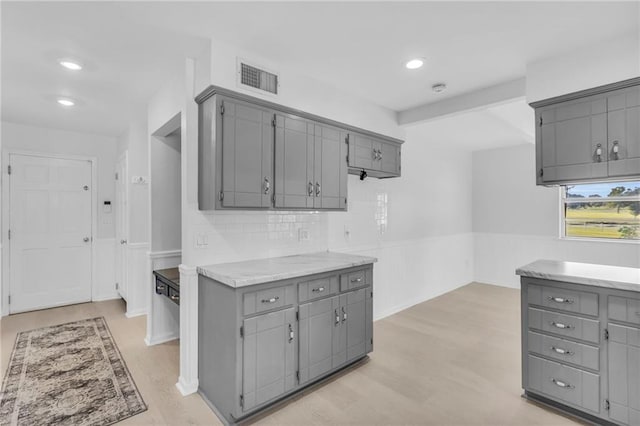 22750 Switzer Rd, Bucyrus, KS 66013 - kitchen with light countertops, wainscoting, gray cabinets, and visible vents