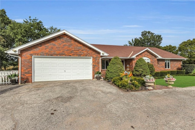 22750 Switzer Rd, Bucyrus, KS 66013 - single story home featuring an attached garage, brick siding, fence, driveway, and a front lawn