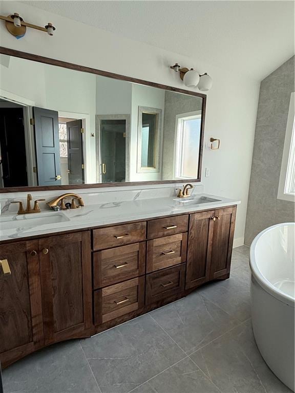 full bath with a freestanding tub, a sink, and double vanity