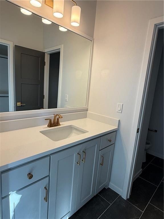 bathroom with vanity, tile patterned flooring, and toilet