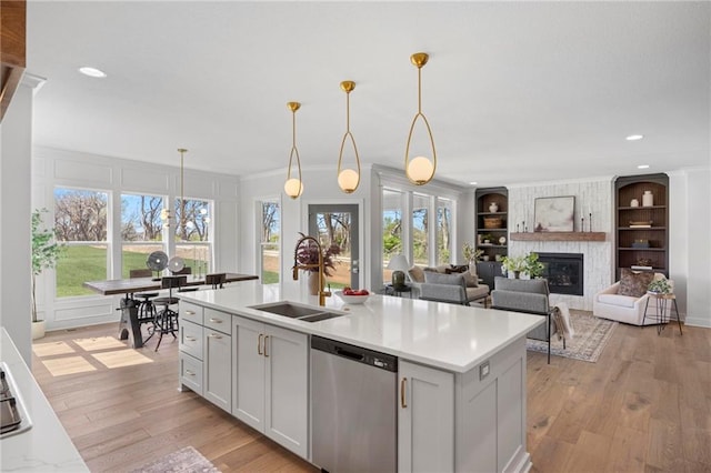18452 Windsor St, Overland Park, KS 66085 - kitchen with light countertops, stainless steel dishwasher, a sink, pendant lighting, and built in features